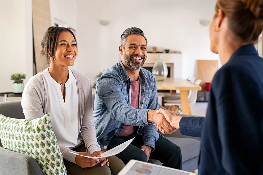 couple shaking hands with a financial planner